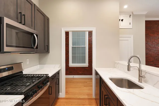 a kitchen with granite countertop a sink and a stove top oven