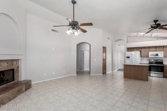 a view of a room with a ceiling fan and a fireplace