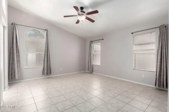 an empty room with windows and fan