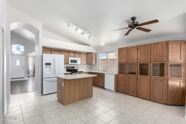 a kitchen with stainless steel appliances granite countertop a refrigerator and a stove top oven