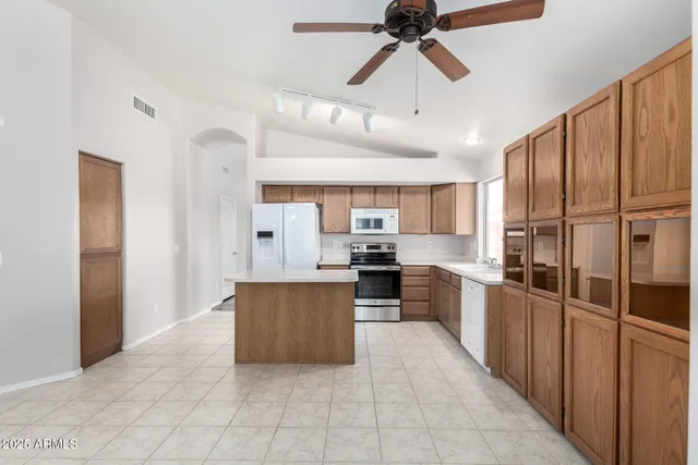 a kitchen with kitchen island white cabinets and stainless steel appliances