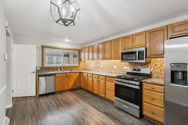 a kitchen with granite countertop stainless steel appliances and wooden cabinets