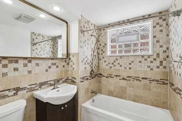 a bathroom with a sink mirror toilet and bathtub