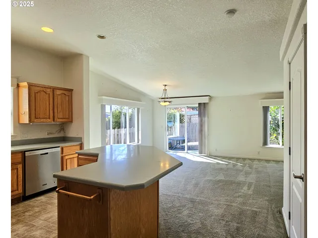a kitchen with stainless steel appliances granite countertop a sink a stove and a refrigerator