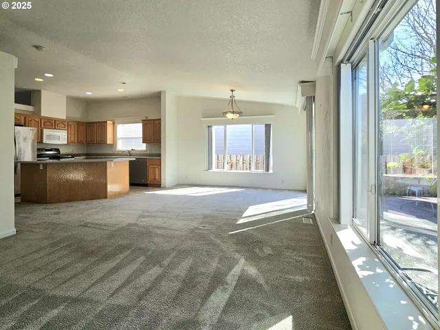a open kitchen with stainless steel appliances granite countertop a stove and a refrigerator