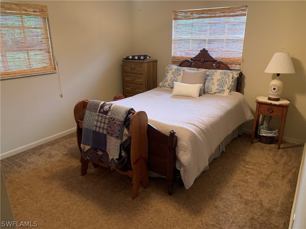 4180 Ellis Road Fort Myers, FL 33905 - Photo 17 of 26 a bedroom with a bed and a lamp on dresser
