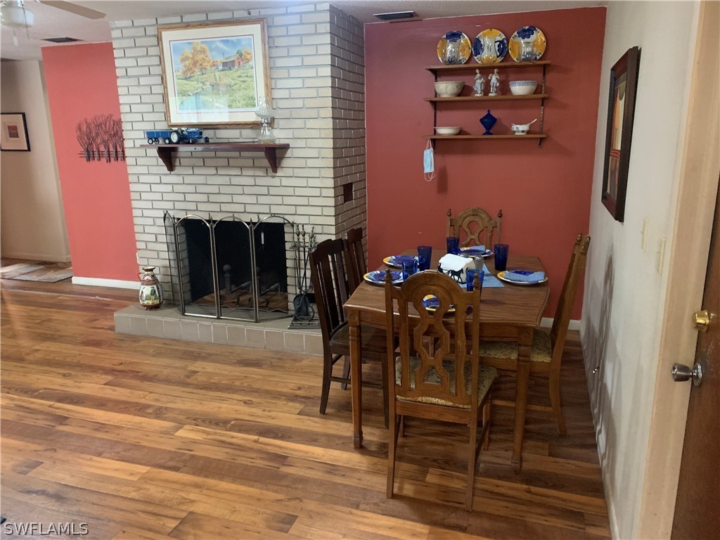 4180 Ellis Road Fort Myers, FL 33905 - Photo 10 of 26 a dining room with furniture wooden floor and a fireplace