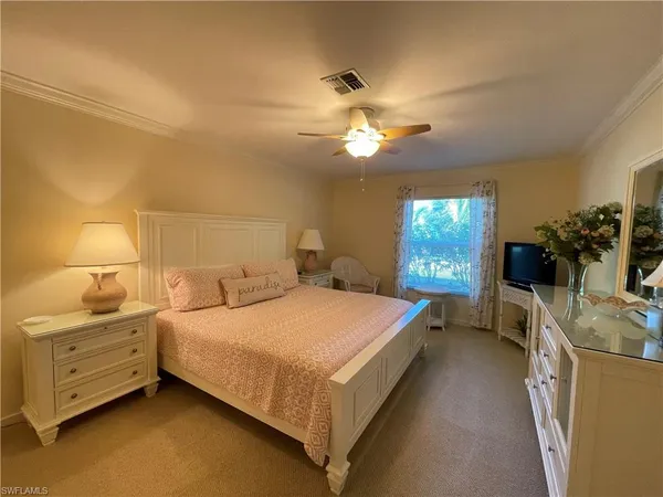 a bedroom with a large bed and a chandelier