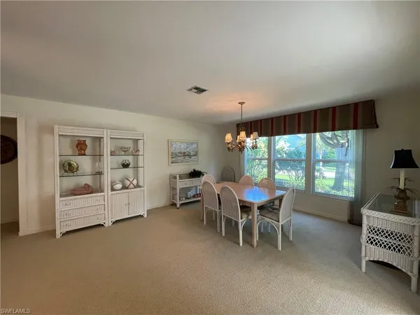 a dining room with furniture a chandelier and window