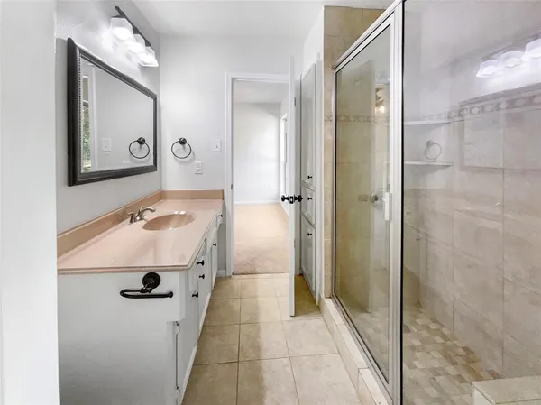 a bathroom with a tub a sink and mirror