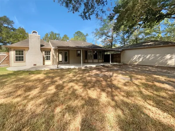 a front view of house with yard and trees in the background