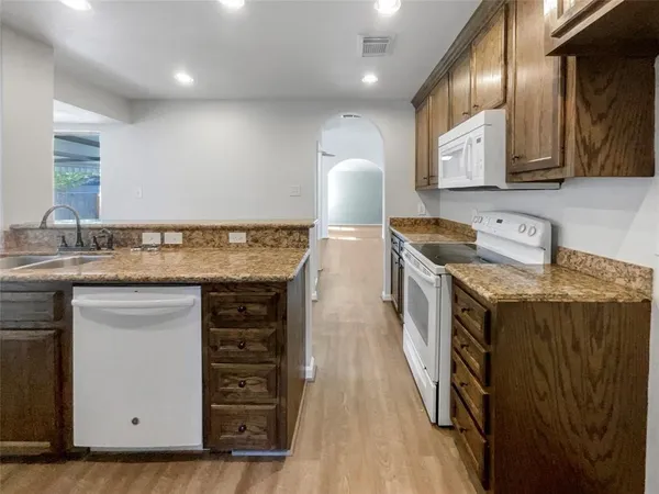 a kitchen with stainless steel appliances granite countertop a sink stove and cabinets