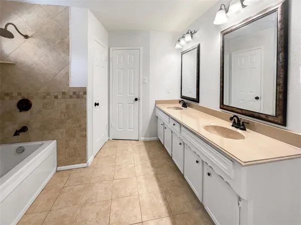 a spacious bathroom with a double vanity sink mirror double and bathtub