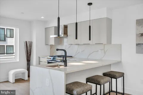 a kitchen with stainless steel appliances a sink a stove a refrigerator and cabinets