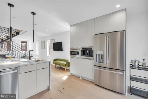 a kitchen with stainless steel appliances a refrigerator sink and microwave
