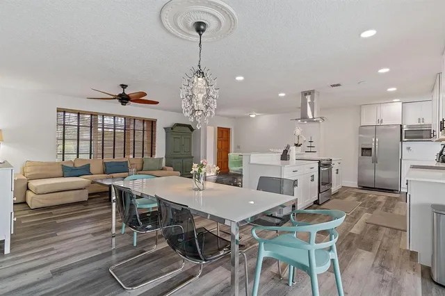 a view of a dining room with furniture a chandelier and wooden floor