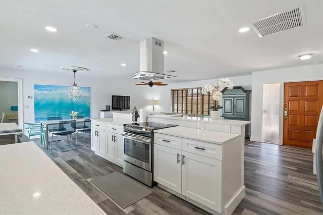 a kitchen with white cabinets and stainless steel appliances