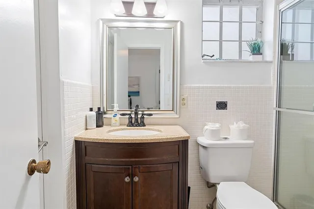 a bathroom with a toilet a sink and mirror