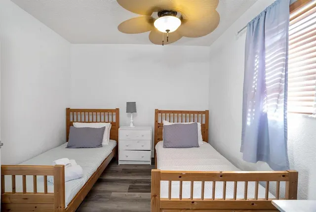 a bedroom with bed and wooden floor