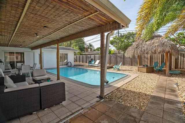 a view of a patio with couches and table and chairs with wooden fence and plants