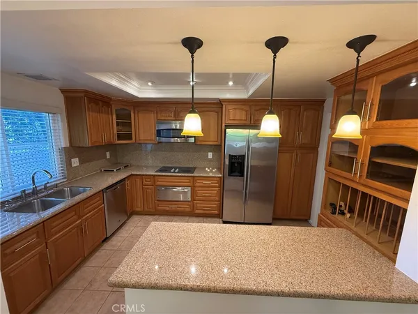 a kitchen with stainless steel appliances granite countertop a sink a stove and a refrigerator