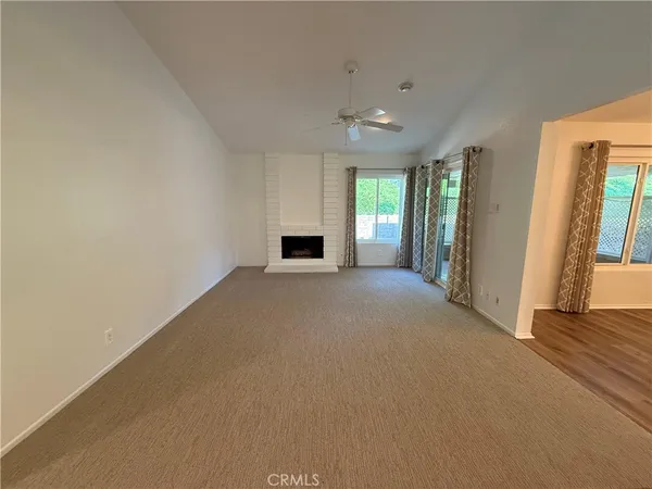 a view of a livingroom with an empty space and a fireplace