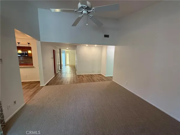 en empty room with windows and ceiling fan