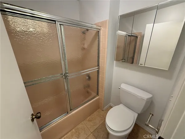 a white toilet sitting next to a shower