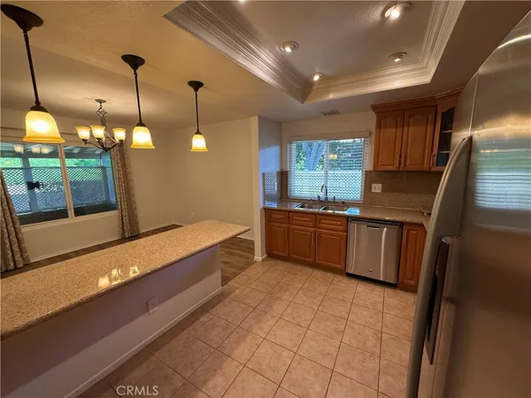 a kitchen with stainless steel appliances granite countertop a sink a stove top oven a counter space and cabinets