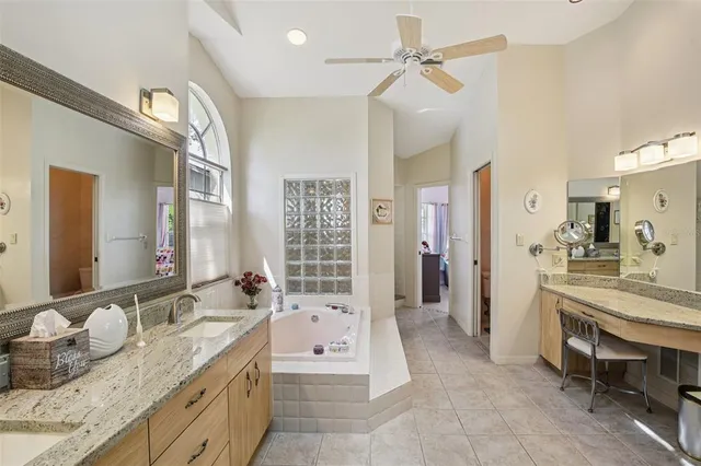 a large bathroom with a granite countertop sink a toilet a mirror and shower