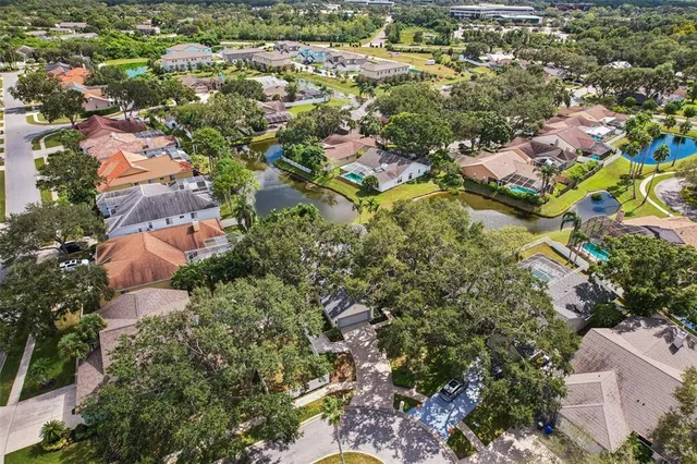 an aerial view of residential houses with outdoor space and trees