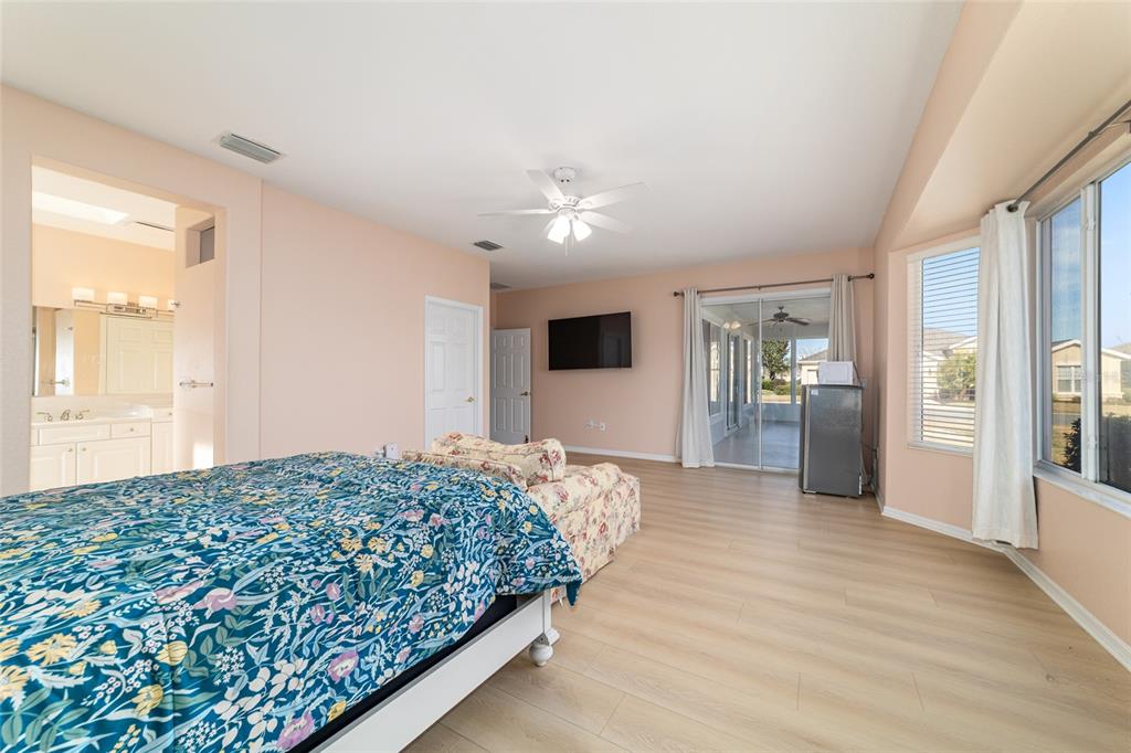 9612 Southeast 124th Loop Summerfield, FL 34491 - Photo 33 of 60 a bedroom with a large bed and a chandelier
