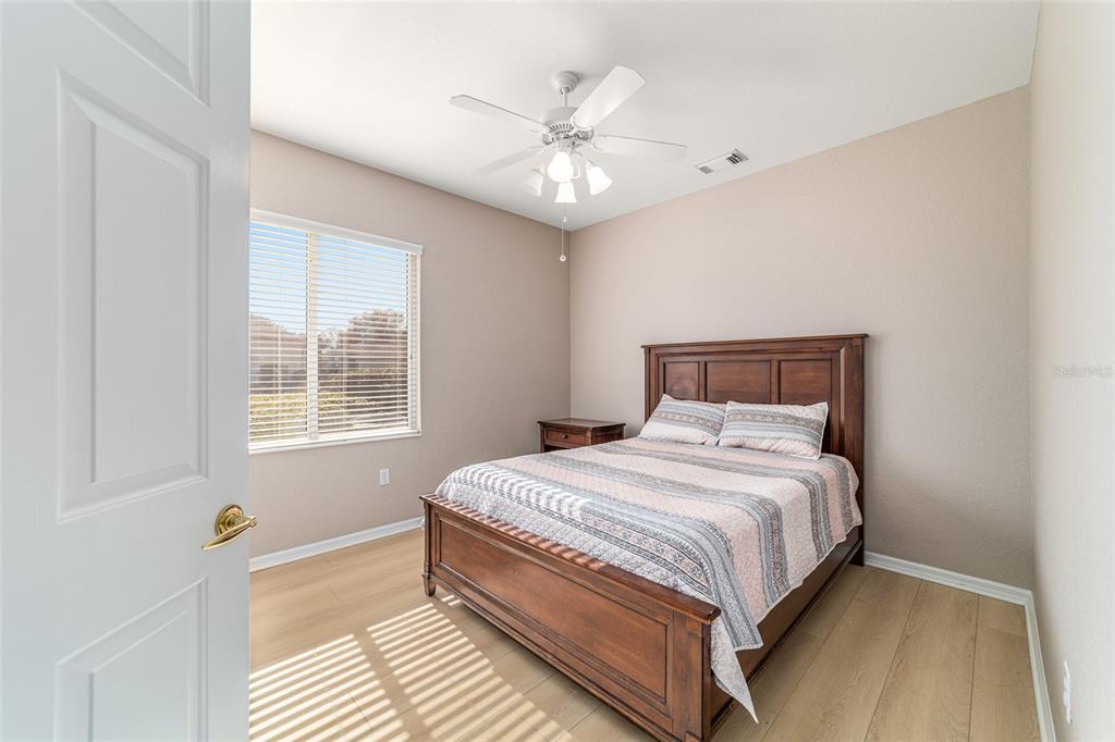 9612 Southeast 124th Loop Summerfield, FL 34491 - Photo 43 of 60 a bedroom with a large bed and a ceiling fan