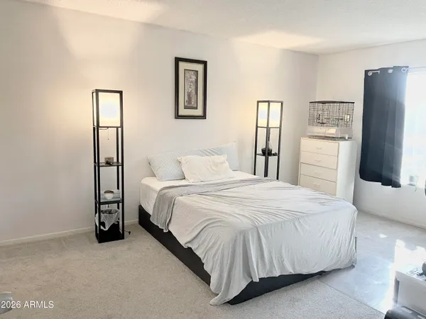 a bedroom with a bed and a refrigerator