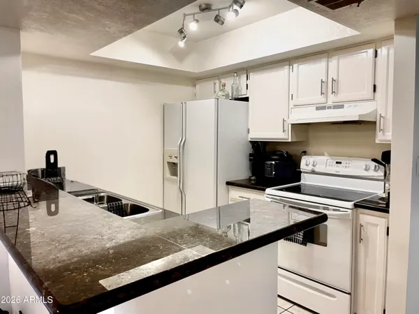 a kitchen with white cabinets and appliances