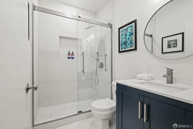 a bathroom with a shower sink vanity and toilet