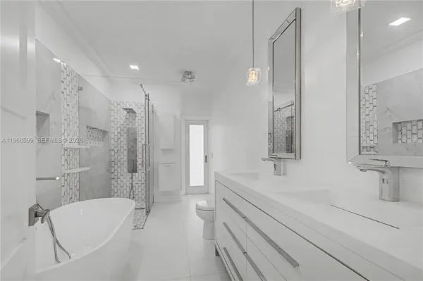 a bathroom with a tub sink shower and mirror