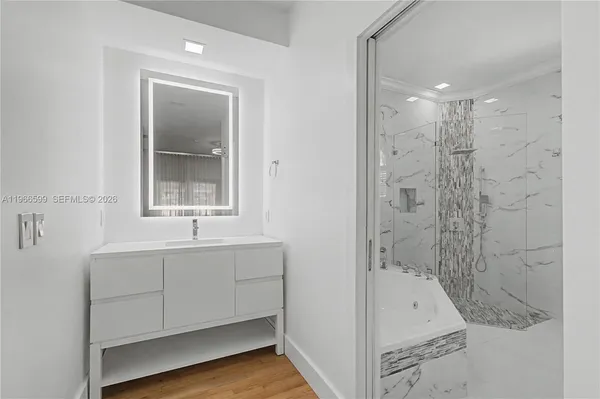 a bathroom with a tub sink shower and mirror