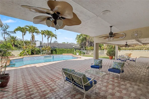a living room with patio furniture and a floor to ceiling window