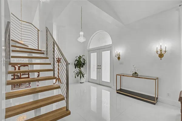 a view of a hallway with staircase and white walls