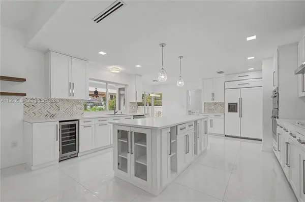 a large kitchen with kitchen island a sink stainless steel appliances and cabinets