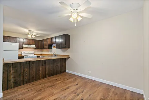 a kitchen with stainless steel appliances a sink cabinets and wooden floor