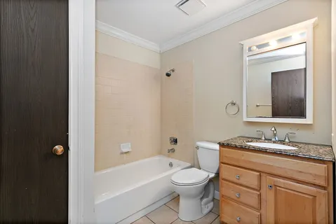 a bathroom with a toilet a sink a tub and mirror