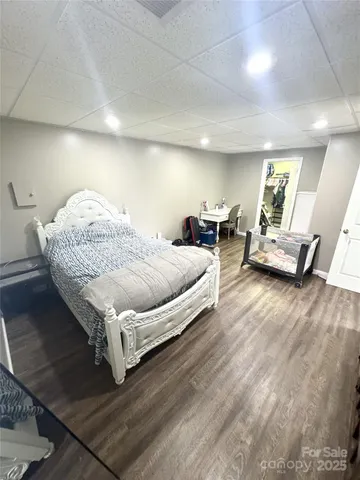 a spacious bedroom with a bed and wooden floor