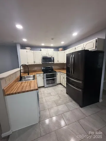 a kitchen with stainless steel appliances granite countertop a refrigerator and a stove top oven