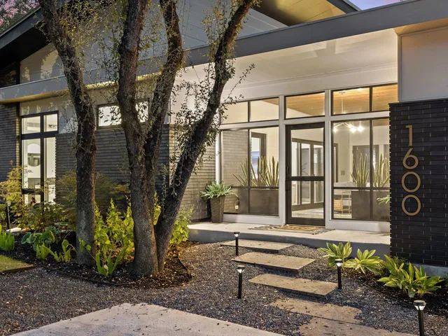 a view of a house with pool and a yard
