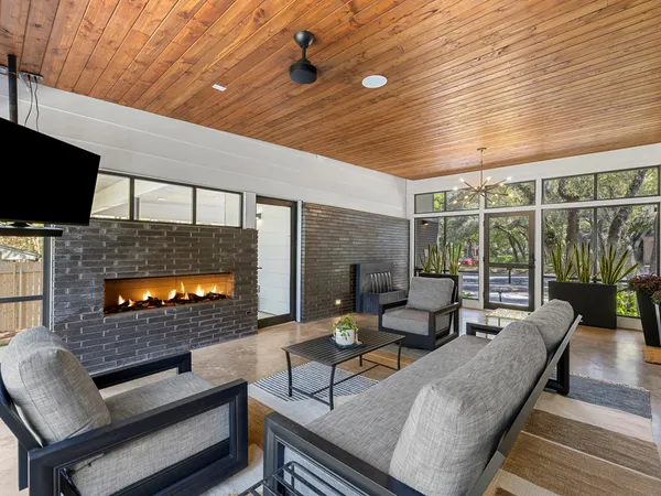 a living room with furniture and a flat screen tv with kitchen view