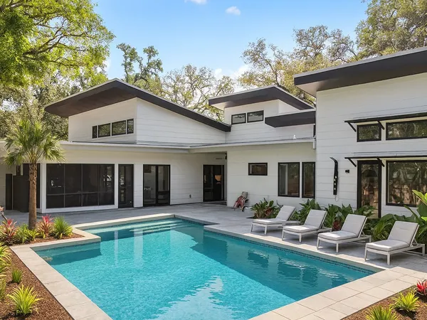 a view of a house with swimming pool and sitting area