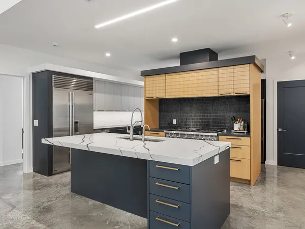 a large kitchen with a stove a sink a refrigerator and a cabinets