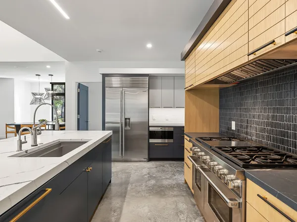 a kitchen with stainless steel appliances granite countertop a sink stove and refrigerator